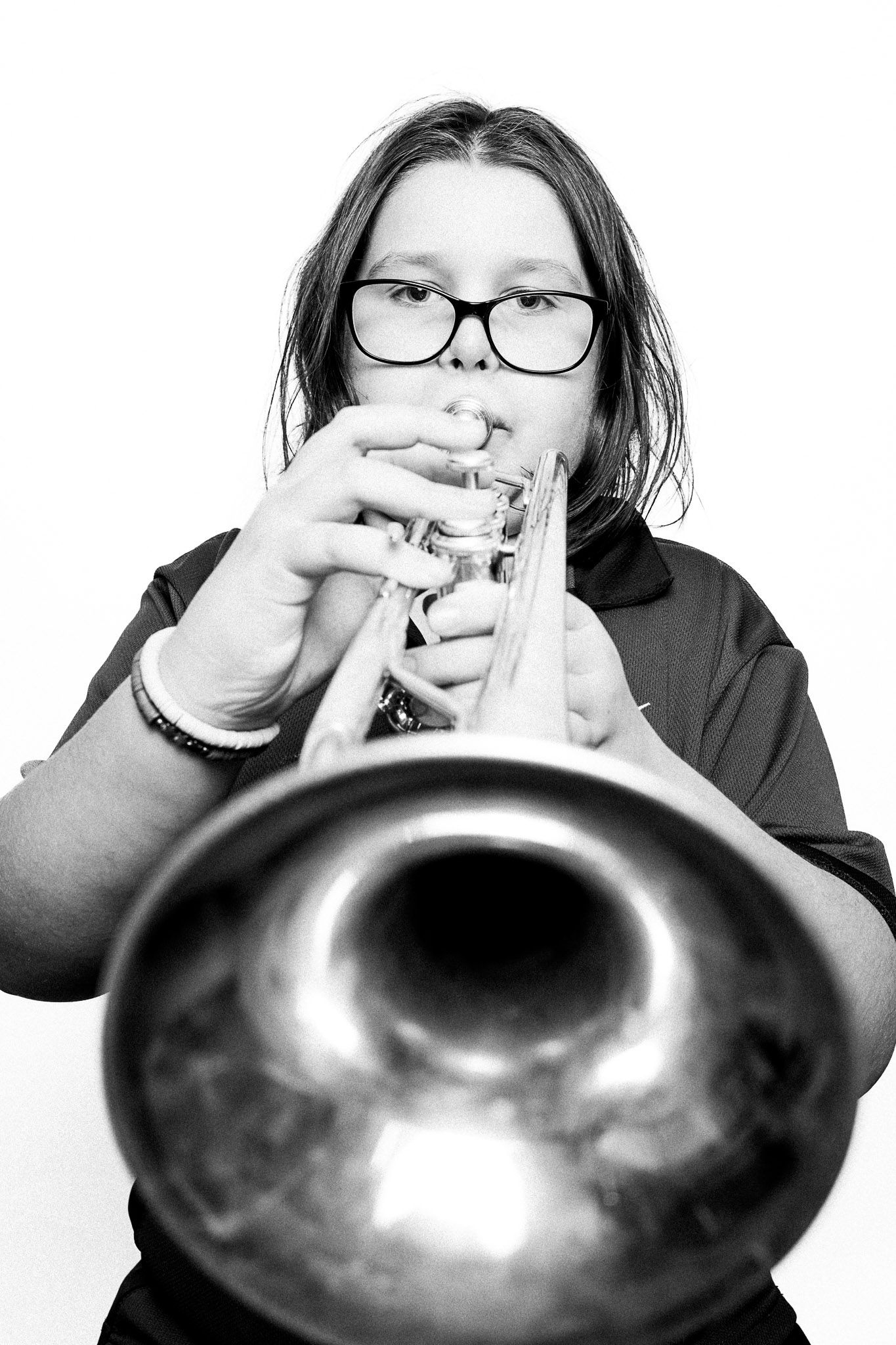 Black and white portrait of a young musician playing a trumpet by Richard Mayle.