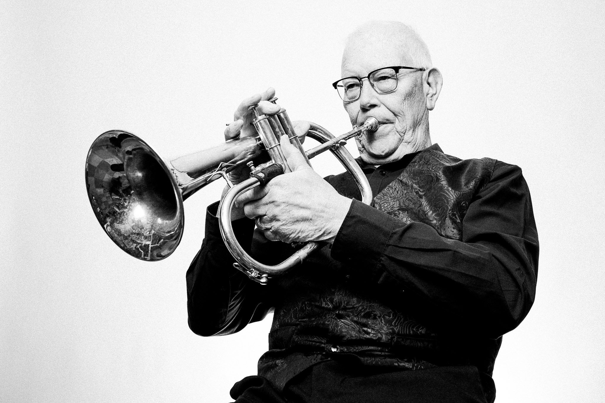 Black and white portrait of a musician playing a flugelhorn by Richard Mayle.