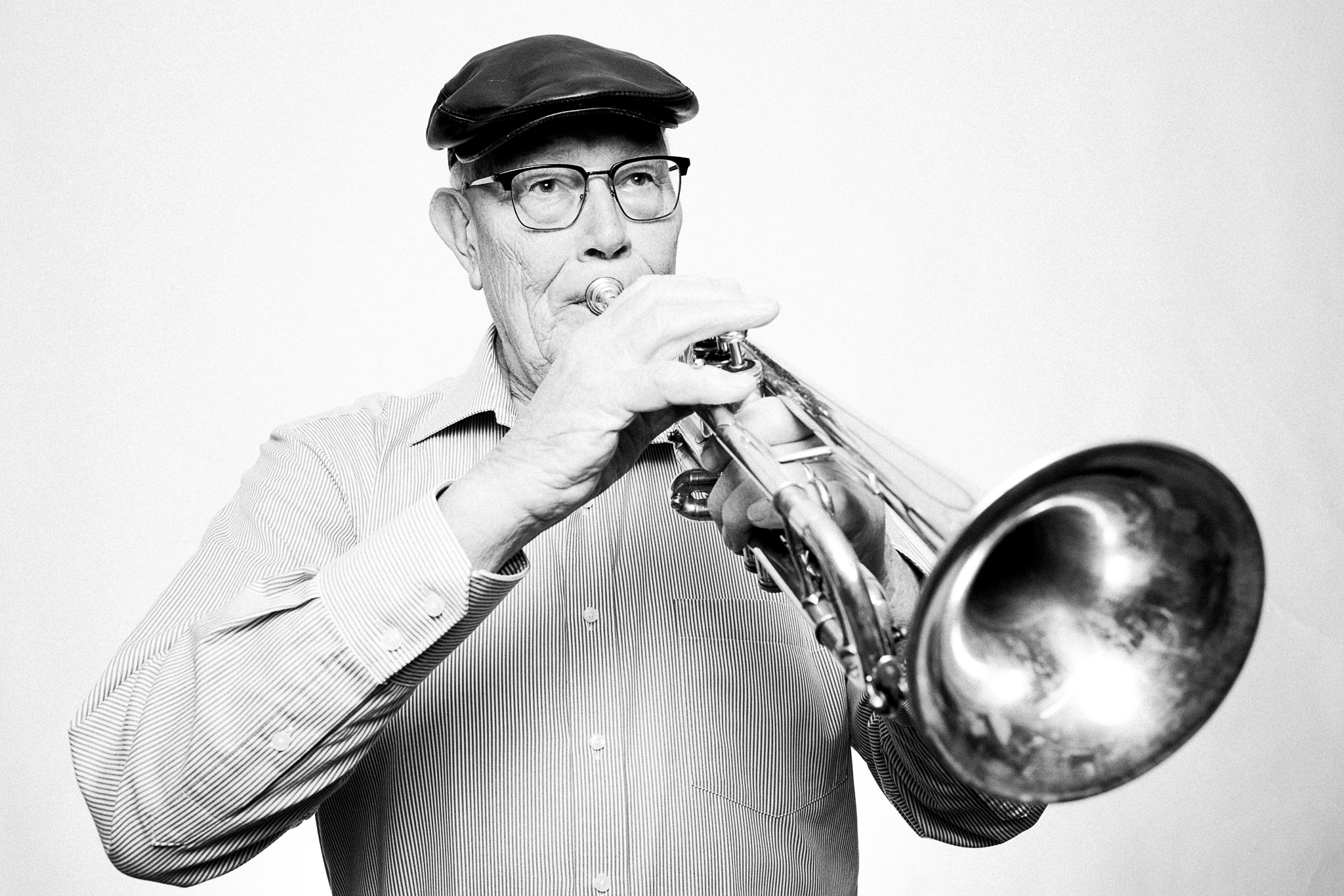 Black and white photograph of a musician playing a trumpet by Richard Mayle.